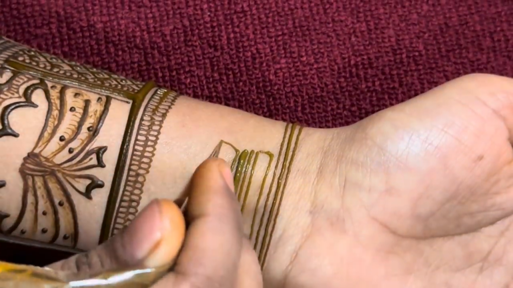 YouTube screenshot of mehndi wrist cuff bands being drawn